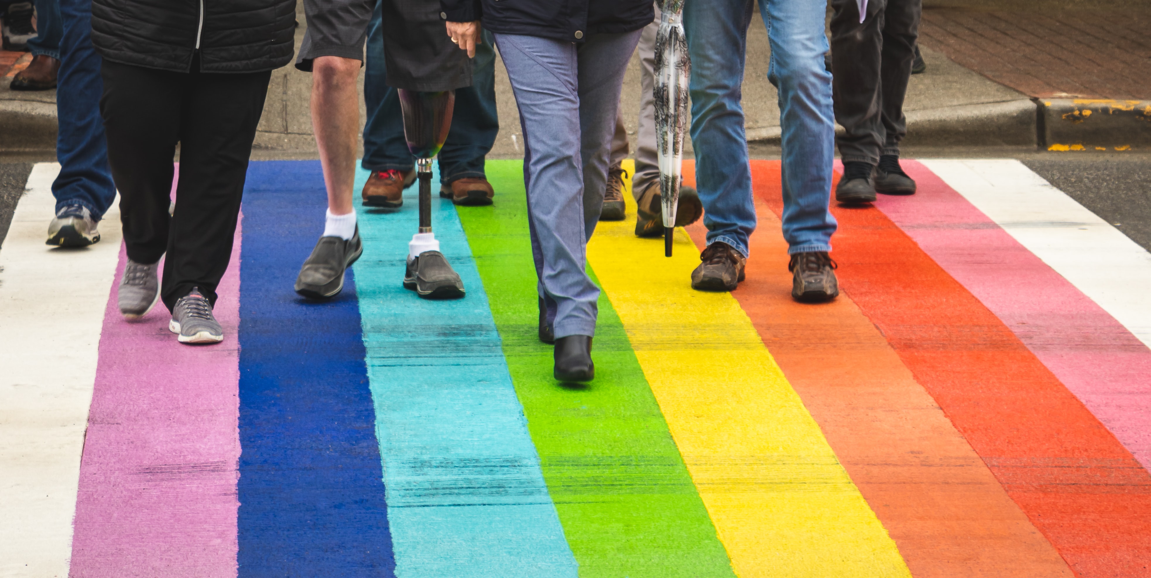 People walking on rainbow street crossing